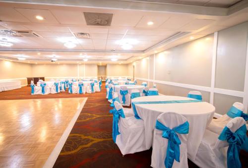 a room with rows of tables and chairs with blue bows at Days Inn and Suites by Wyndham Hammond, IN in Hammond