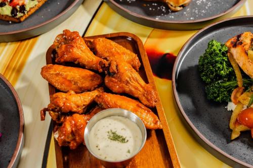 a plate of food with chicken and broccoli on a table at Hotel Indigo Austin Downtown - University by IHG in Austin