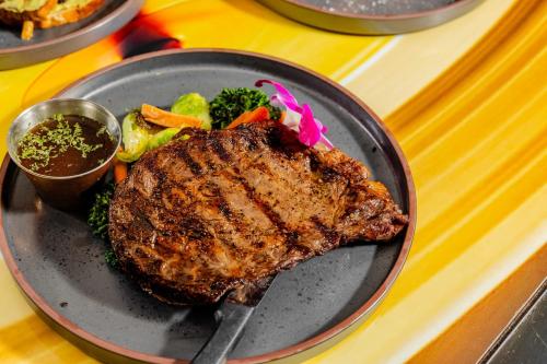 a plate with a steak and vegetables on a table at Hotel Indigo Austin Downtown - University by IHG in Austin