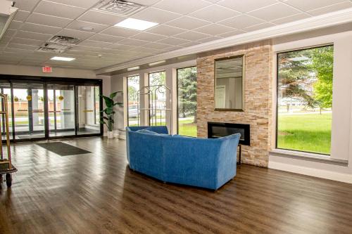 a living room with a blue couch in front of a fireplace at Days Inn and Suites by Wyndham Hammond, IN in Hammond