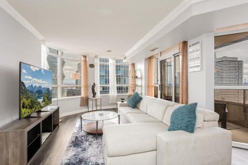 a living room with a couch and a tv at Sky Retreat | 2BR-2BA High Floor | 180° City View in Mississauga