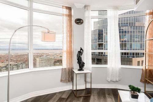 a room with large windows with a cat statue on a table at Sky Retreat | 2BR-2BA High Floor | 180° City View in Mississauga