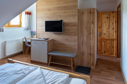 a bedroom with a desk and a tv on a wall at Jihočeská Salaš in Čakov
