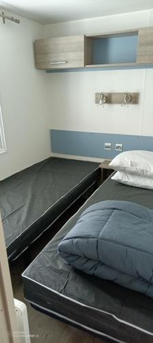 une chambre avec deux lits dans une pièce dans l'établissement Mobil Home Oléron, à La Celle-sous-Gouzon