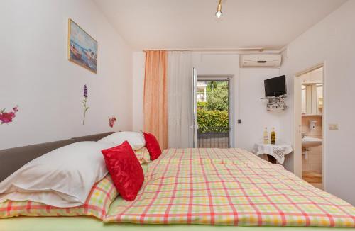 a bedroom with a bed with red pillows on it at Apartments Galić in Mlini