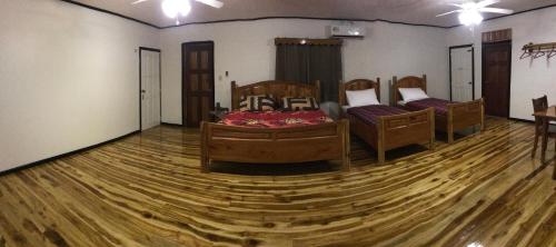 a room with three beds and a wooden floor at Tropical Magnolia in Hellgate