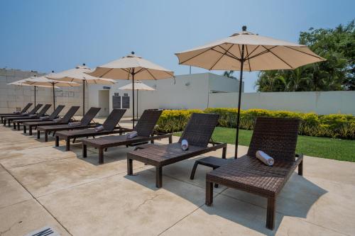 a row of chairs and umbrellas on a patio at Holiday Inn Acapulco La Isla by IHG in Acapulco