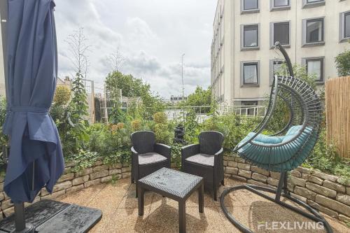 un groupe de chaises et un miroir sur une terrasse dans l'établissement Bright apartment with garden close to the metro, à Paris
