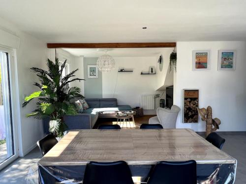 un salon avec une table et un canapé dans l'établissement Maison charmante avec piscine - 6 personnes - proche mer, à Saint-Gilles-Croix-de-Vie