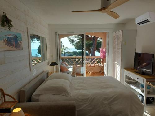 une chambre avec un lit et une télévision et un balcon dans l'établissement Vue mer exceptionnelle, à Sainte-Maxime
