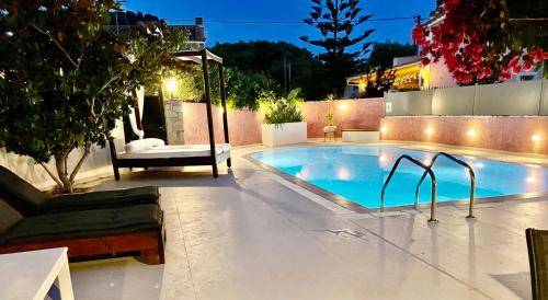 a swimming pool in a backyard at night at Neptune family Villa in Zakynthos Town