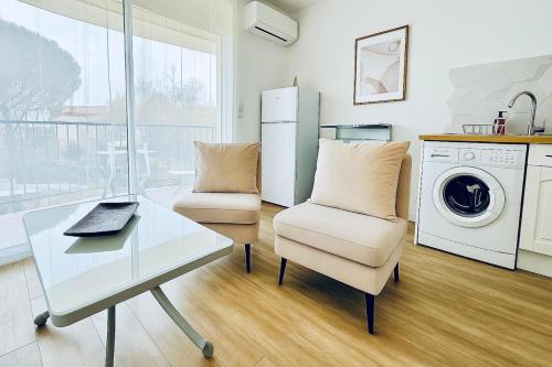 une cuisine avec un bureau et une chaise ainsi qu'une laveuse et une sécheuse dans l'établissement Studio Chanzy lumineux cozy avec terrasse Narbonne, à Narbonne