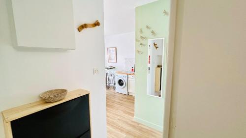 un salon avec une télévision et un couloir avec une cuisine dans l'établissement Studio Chanzy lumineux cozy avec terrasse Narbonne, à Narbonne