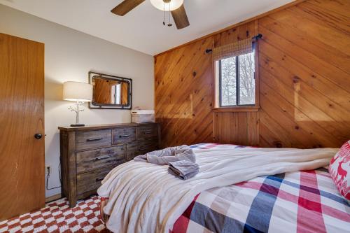 a bedroom with a bed and a wooden wall at Moose Tracks Cabin Hot Tub 1 Mile To Lake in Lake Harmony