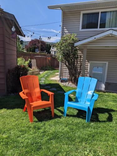 two colorful chairs sitting in the grass in a yard at Private SweetSuite 1 Bdrm Bathroom mini-kitchen in Kamloops