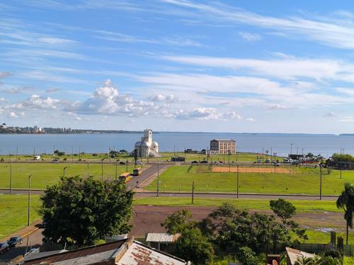a view of a park with a statue in front of the water at Dpto a pasos de la playa San José in Encarnación