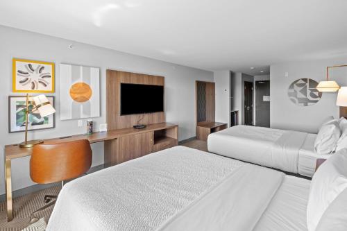 a hotel room with two beds and a flat screen tv at Holiday Inn Hotel & Suites Surrey East - Cloverdale by IHG in Surrey