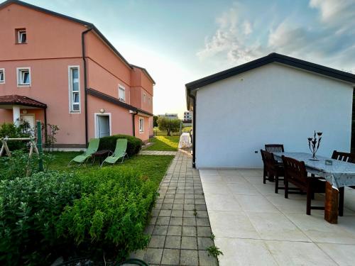 a backyard with a table and chairs and a building at Guest House Gloria in Novigrad Istria