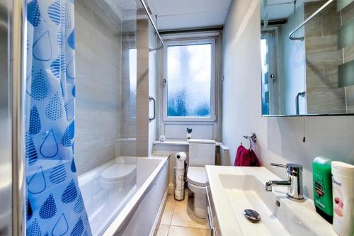 a bathroom with a tub and a toilet and a sink at Edinburgh Drumdryan Central Apartment in Edinburgh