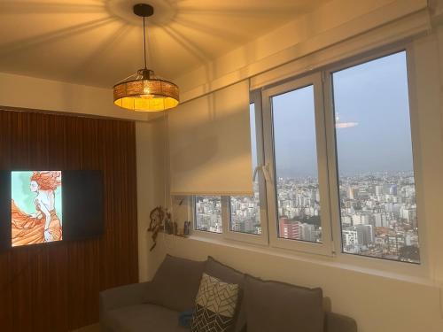 リマにあるdepartamento de estreno con espectacular vistaのソファと2つの窓があるリビングルーム