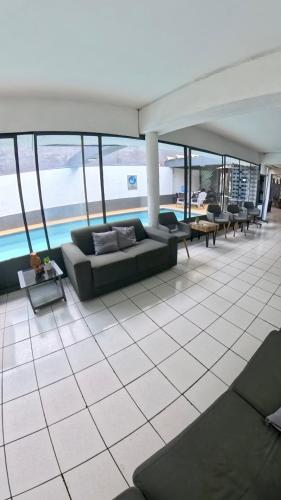 a living room with a couch and tables and windows at Hotel Concorde in Arica