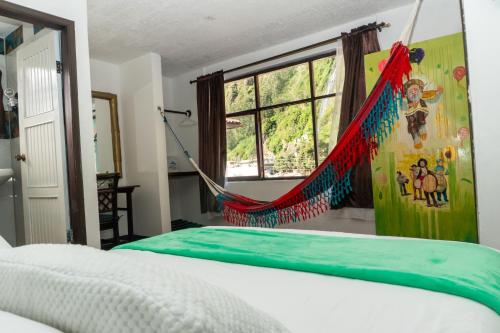 a hammock in a bedroom with a bed at Hotel De Mi Pueblo in Baños