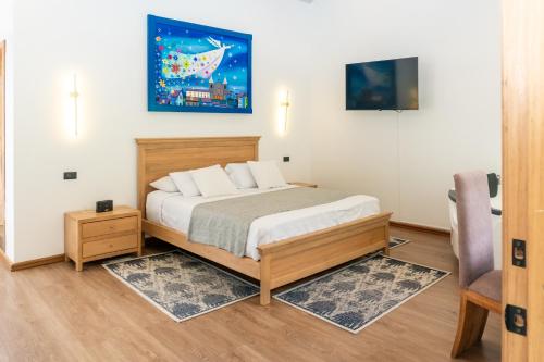 a bedroom with a bed and a tv and a chair at Hotel De Mi Pueblo in Baños