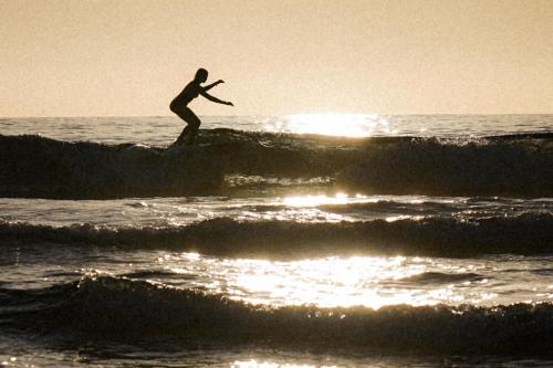 a man riding a wave on a surfboard in the ocean at CABRA - Porto Covo in Porto Covo