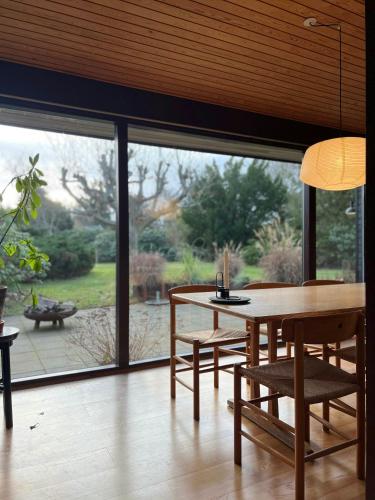 a dining room with a table and chairs and a large window at Enjoy Nature And Water In Rågeleje Near Vejby in Vejby