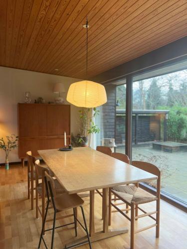 a dining room with a wooden table and chairs at Enjoy Nature And Water In Rågeleje Near Vejby in Vejby