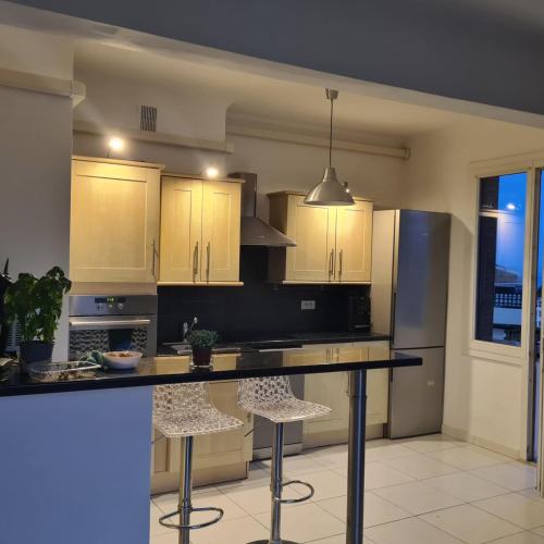 La cuisine est équipée d'un comptoir avec tabourets et d'un réfrigérateur. dans l'établissement Beautiful 3-room apartment sea view, à Nice