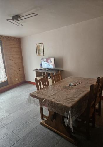 une salle à manger avec une table et des chaises en bois dans l'établissement Appartement plein centre ville de Bozel, à Bozel