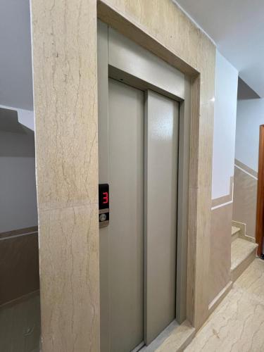 an elevator door in a building with a clock on it at Résidence Assalam - en bord de mer in Azla