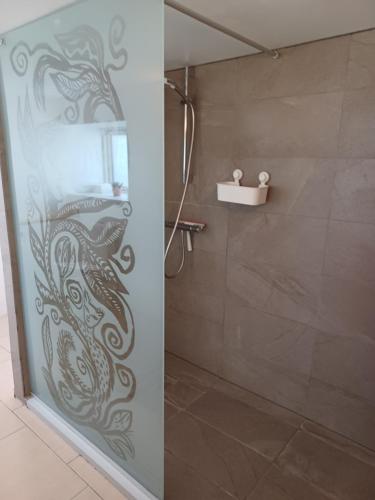 a shower with a glass door with a fish painted on it at Kjærgaarden B&B - Bed & Breakfast i Havnsø in Føllenslev