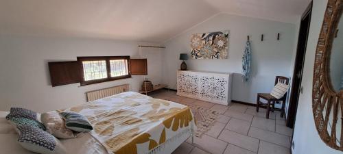 Un dormitorio con una cama y una silla dentro. en Casa del Menhir, cammino Materano e ciclovia, en Cassano delle Murge