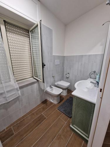 a white bathroom with a toilet and a sink at Domus Conza in Nocera Inferiore