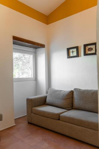 a living room with a couch and a window at Vila Bita Agroturismo in Almodôvar
