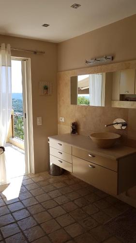 une salle de bain avec un lavabo et un grand miroir dans l'établissement Villa 06, à Le Tignet