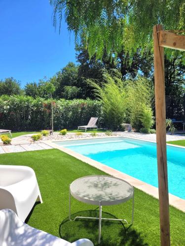 - une piscine avec une table dans l'herbe dans l'établissement Villa raffinée, piscine, jardin, proche Cassis et Marseille, à Aubagne
