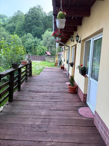 a wooden walkway outside a house with potted plants at American Dream in Şimon