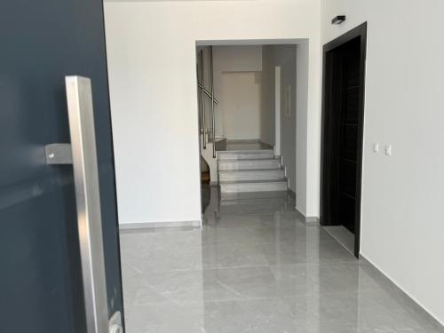 a hallway with white walls and a hallway with stairs at Comfort SpataAir Stay in Spáta