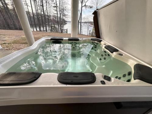 a jacuzzi tub in the backyard of a house at Modern Lakefront Oasis Unwind in Comfort & Style in Flowery Branch