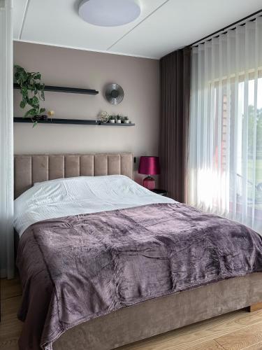 una camera con un letto e una coperta viola di RG Aisa Apartment a Pärnu
