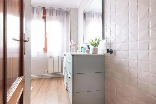 a bathroom with a counter and a sink and a window at Mi casita del norte a 150 m de la playa in Mogro