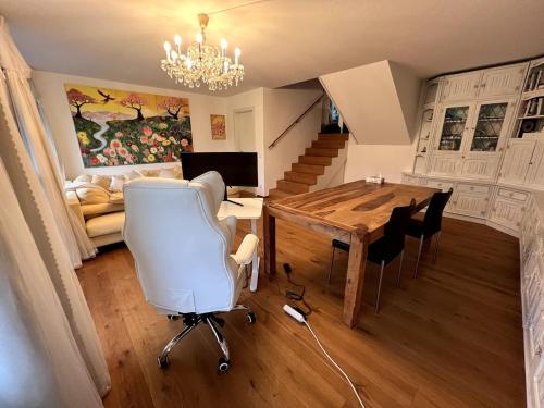 a living room with a table and chairs and a couch at Moderne familienfreundliche Garten-Maisonette in Bregenz