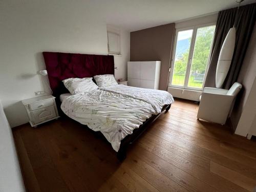 a bedroom with a bed and a large window at Moderne familienfreundliche Garten-Maisonette in Bregenz