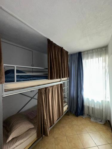 a bedroom with a bunk bed and a window at Room Hostel Tolebi in Almaty