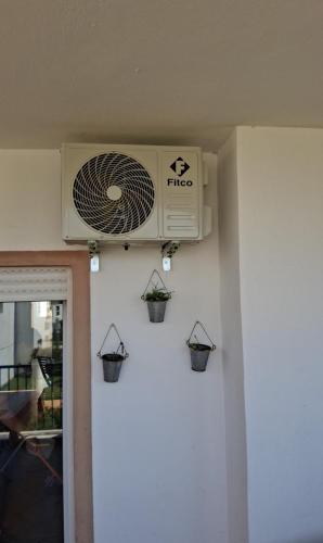 a air conditioner on a wall with three flower pots at Marina Saidia AP8 LILIA in Saidia 
