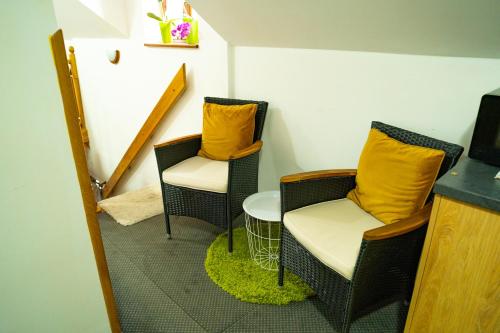 two chairs with yellow pillows in a room at Penzión Zvala in Pichne