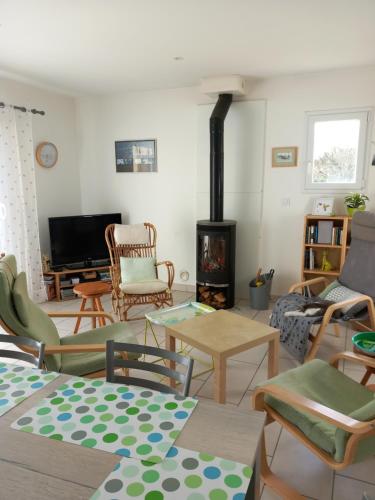 - un salon avec une cheminée, des tables et des chaises dans l'établissement Entre terre et mer, à La Celle-sous-Gouzon